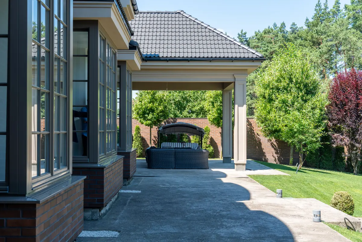 A covered concrete patio with support posts landing on the slab