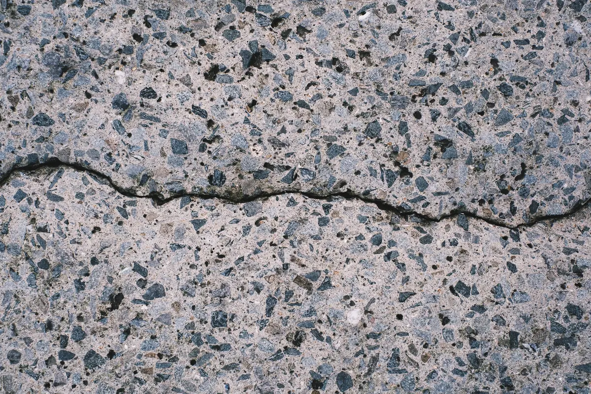 A widening crack running through a concrete slab surface