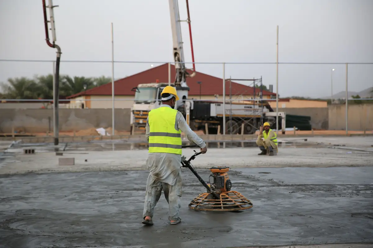 A power trowel finishing a large concrete surface