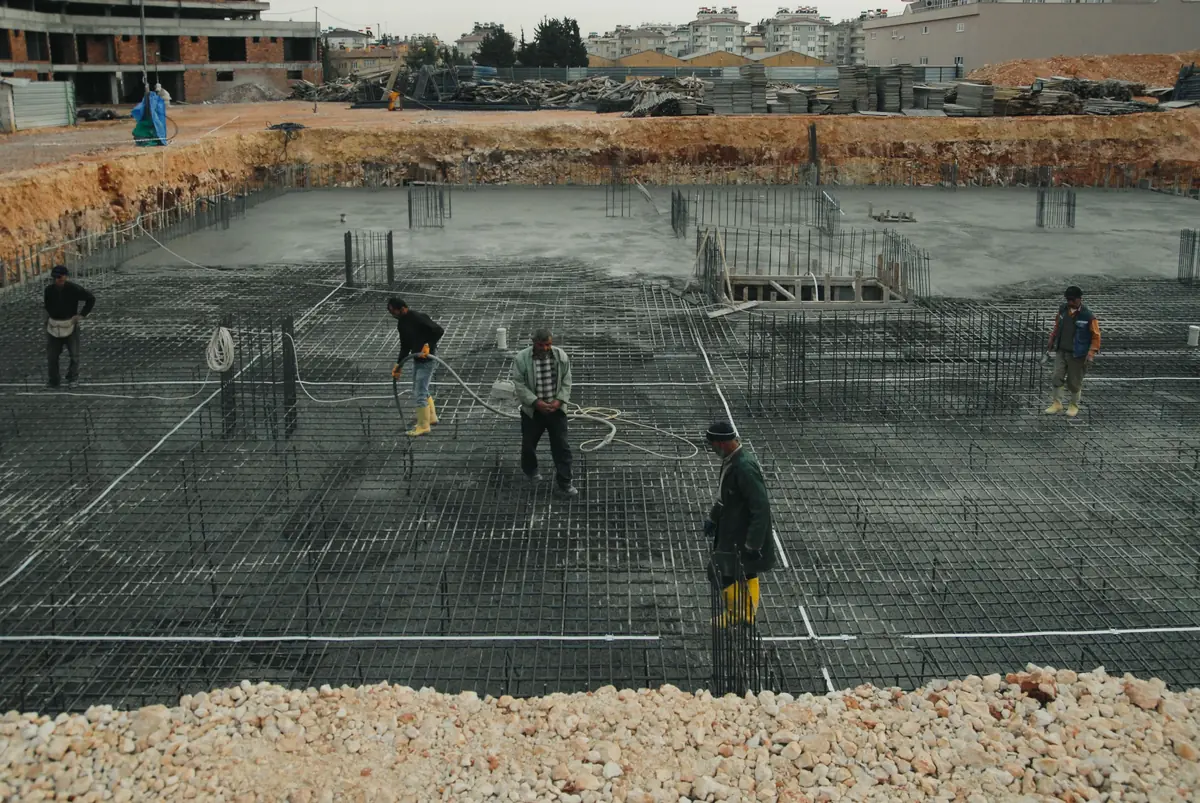 Timber formwork and a steel reinforcement grid set over compacted base before a slab pour